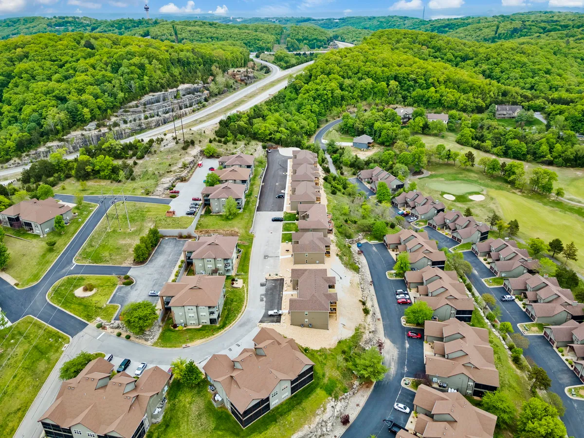 A cluster of residential buildings sits adjacent to lush greenery and a nearby golf course, illustrating how close the accommodations are to the fairways. The relaxed, community-oriented setting reflects easy access to outdoor activities.