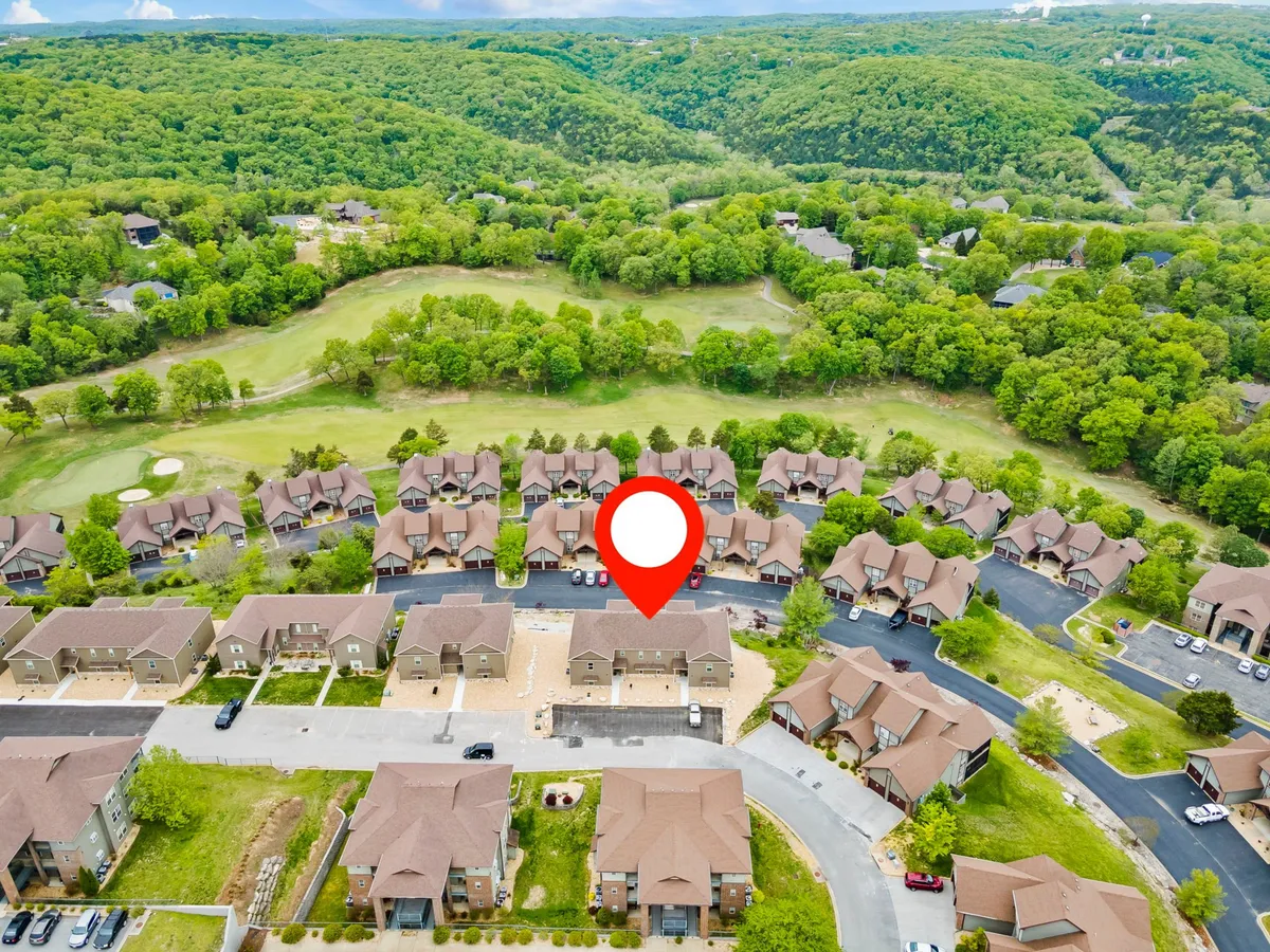 This image captures a sweeping view of green hills, the resort’s neighborhood layout, and the adjacent golf course. The open landscape and pathways are ideal for walking, jogging, or simply soaking in the natural surroundings of the Ozark hills.